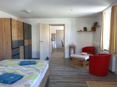 Schlafzimmer mit Sitzecke und Blick in Richtung Esszimmer