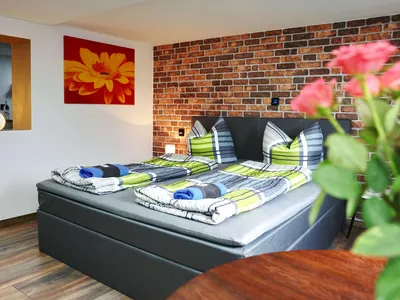 Gemütliche Sitzecke im Schlaf- und Wohnbereich mit Blick auf das Bett