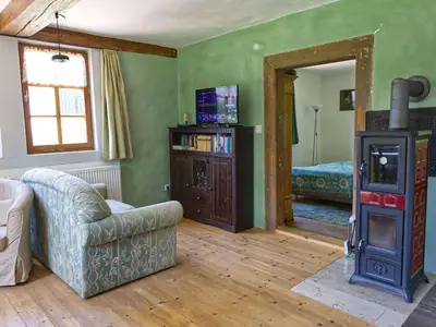 Wohnzimmer mit Ofen und TV