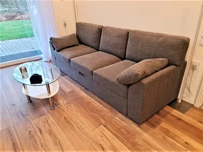 Das gemütliche Sofa ist ausziehbar und lädt zum Entspannen ein.