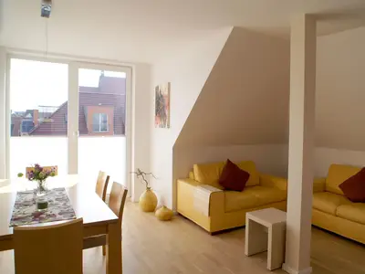 Wohnzimmer mit Essbereich und Zugang zum Balkon