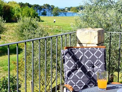 Der Balkon mit Meerblick, Tisch, Stühlen und Sonnenschirm