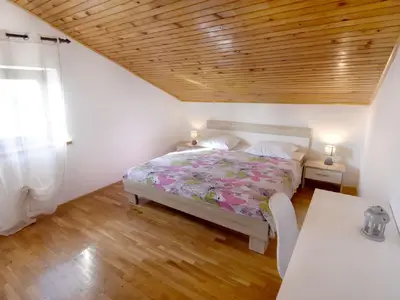 Das Schlafzimmer mit Doppelbett, Schreibtisch und Nachttischen mit Nachtlampen