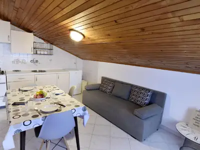 Der Wohnbereich mit Küche, Esstisch und Sofa