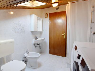 Das Badezimmer mit Dusche, Waschmaschine, Toilette, Bidet und Waschbecken
