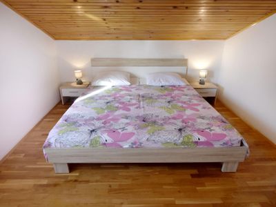 Das Schlafzimmer mit Doppelbett, zwei Nachttischen mit Nachtlampen
