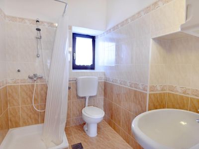 Das Badezimmer mit Dusche, WC, Waschbecken