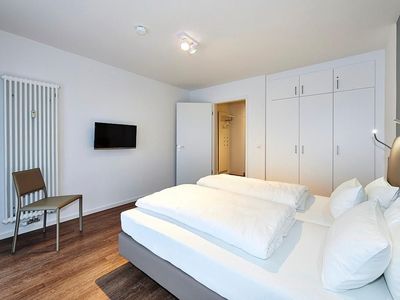 Schlafzimmer mit Doppelbett, Kleiderschrank und Flatscreen TV