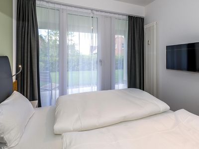 Schlafzimmer mit Doppelbett, Flatscreen-TV und Zugang zur Terrasse