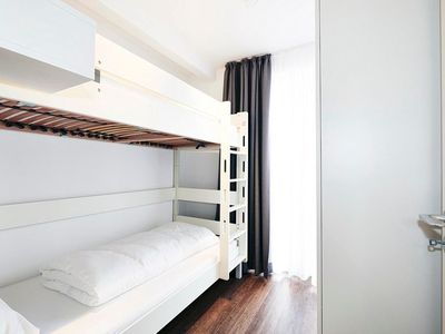 Schlafzimmer mit Stapelbett und Kleiderschrank