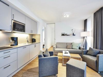 Wohn-Kochbereich mit Küchenzeile, Sofa und Sessel