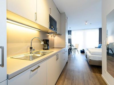 Wohn/Essbereich mit Küchenzeile, Doppelbett und Esstisch