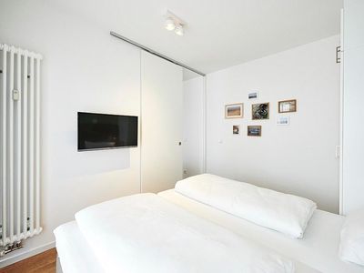 Schlafzimmer mit Doppelbett und Flatscreen TV