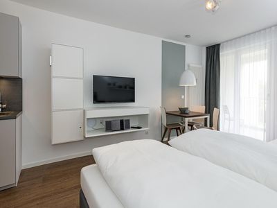 Wohn-Ess-Schlafbereich mit Doppelbett, Esstisch, Sitzgelegenheit und Flatscreen TV