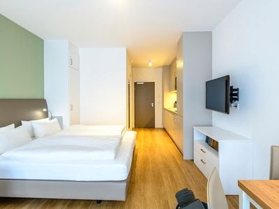 Wohn/Essbereich mit Doppelbett, TV, Kleiderschrank und Küchenzeile
