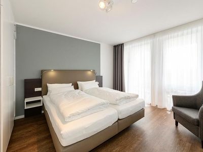 Schlafzimmer mit Doppelbett, Sessel und Kleiderschrank