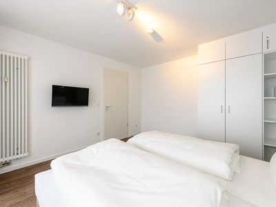 Schlafzimmer mit Doppelbett, TV und Kleiderschrank