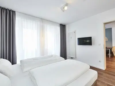 Schlafzimmer mit Doppelbett und TV