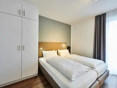 Schlafzimmer mit Doppelbett und Kleiderschrank