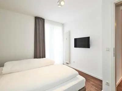 Schlafzimmer mit Doppelbett und TV