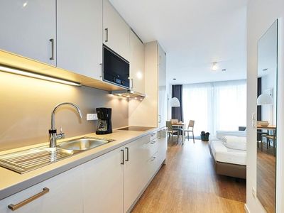 Wohn/Essbereich mit Küchenzeile, Doppelbett und Esstisch