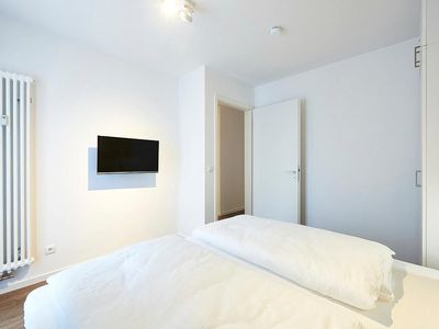 Schlafzimmer mit Doppelbett, Kleiderschrank und TV