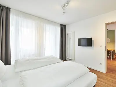 Schlafzimmer mit Doppelbett und TV