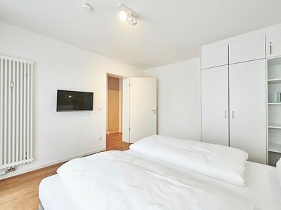 Schlafzimmer mit Doppelbett, Kleiderschrank und TV