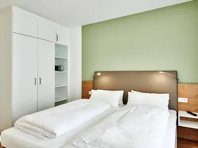 Schlafzimmer mit Doppelbett und Kleiderschrank