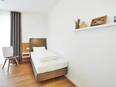Schlafzimmer mit zwei Einzelbetten und Stuhl