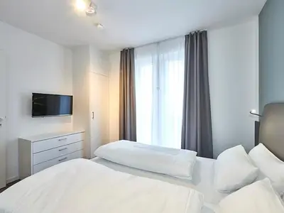 Schlafzimmer mit Doppelbett und TV