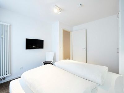 Schlafzimmer mit Doppelbett, TV und Kleiderschrank