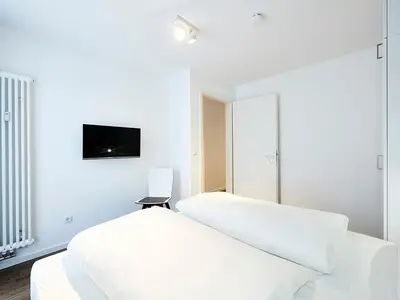 Schlafzimmer mit Doppelbett, TV und Kleiderschrank