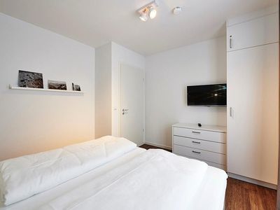 Schlafzimmer mit Doppelbett, Kleiderschrank und Flatscreen-TV