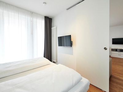 Schlafbereich mit Flatscreen-TV, Blick in den Wohnbereich