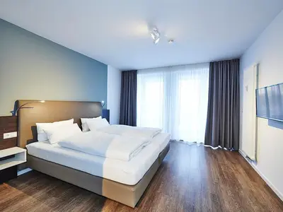 Schlafzimmer mit Doppelbett und Zugang zum Balkon