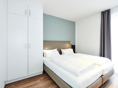 Schlafzimmer mit Doppelbett und Kleiderschrank