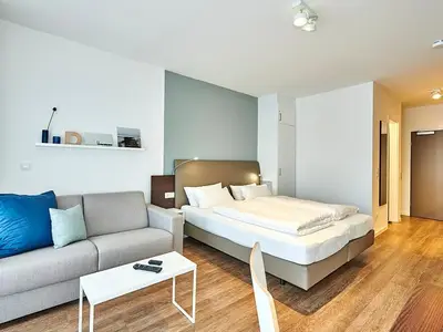 Wohn-Schlafbereich mit Couch und Doppelbett