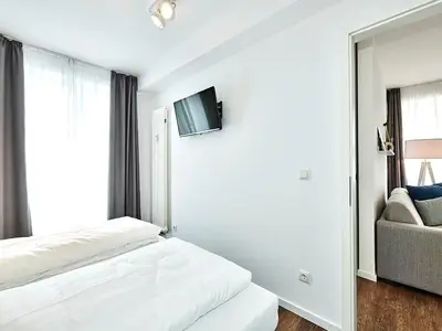 Schlafzimmer mit Doppelbett, Kleiderschrank und Flatscreen TV