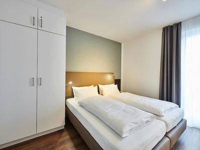 Schlafzimmer mit Doppelbett, Kleiderschrank und Flatscreen TV