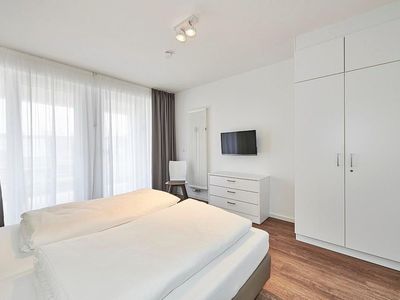 Schlafzimmer mit Doppelbett, Flatscreen-TV und Kleiderschrank