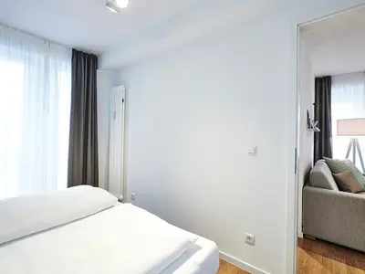 Schlafzimmer mit Doppelbett und Zugang zum Balkon