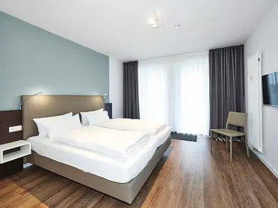 Schlafzimmer mit Doppelbett und Zugang zum Balkon