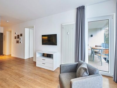 Wohnbereich mit Flatscreen-TV und Zugang zum Balkon