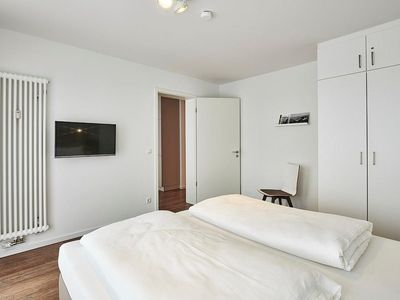 Schlafzimmer mit Doppelbett, Kleiderschrank und Flatscreen TV