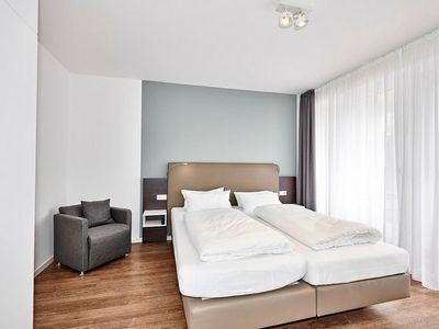Schlafzimmer mit Doppelbett, Kleiderschrank, Flatscreen TV und Zugang zur Terrasse