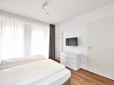 Schlafzimmer mit Doppelbett, Flatscreen-TV und Zugang zur Terrasse