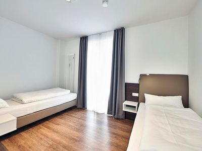 Schlafzimmer mit zwei Einzelbetten und Kleiderschrank