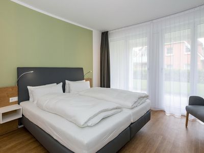 Schlafzimmer mit Doppelbett und Zugang zur Terrasse