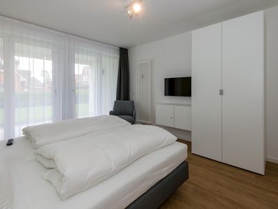 Schlafzimmer mit Doppelbett, Kleiderschrank und Flatscreen TV